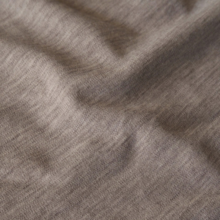 Close-up of beige merino wool jersey fabric with visible texture