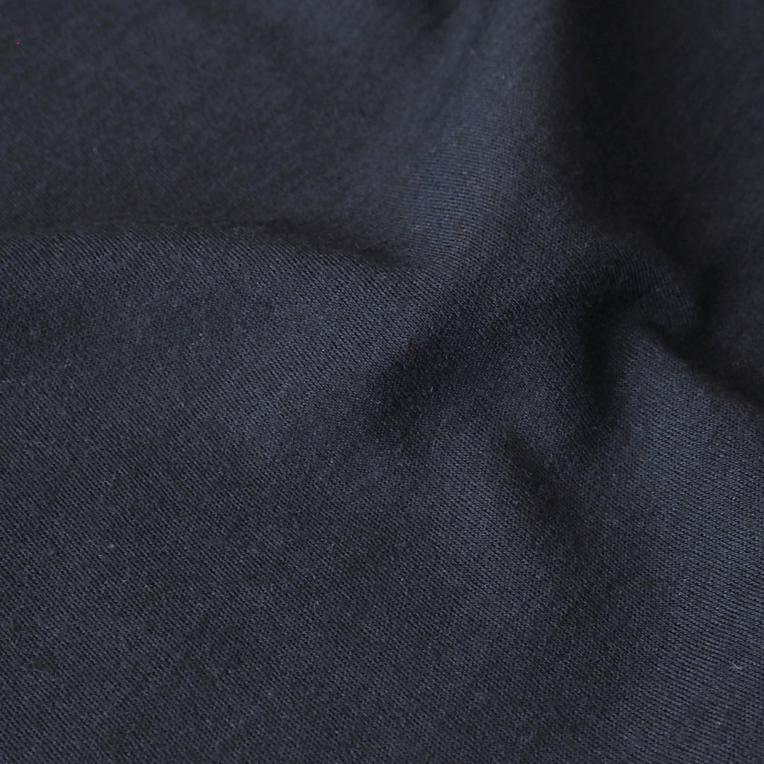Close-up of navy blue merino wool jersey fabric with visible texture