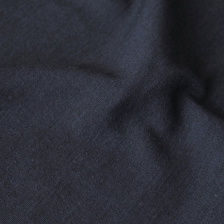 Close-up of navy blue merino wool jersey fabric with visible texture