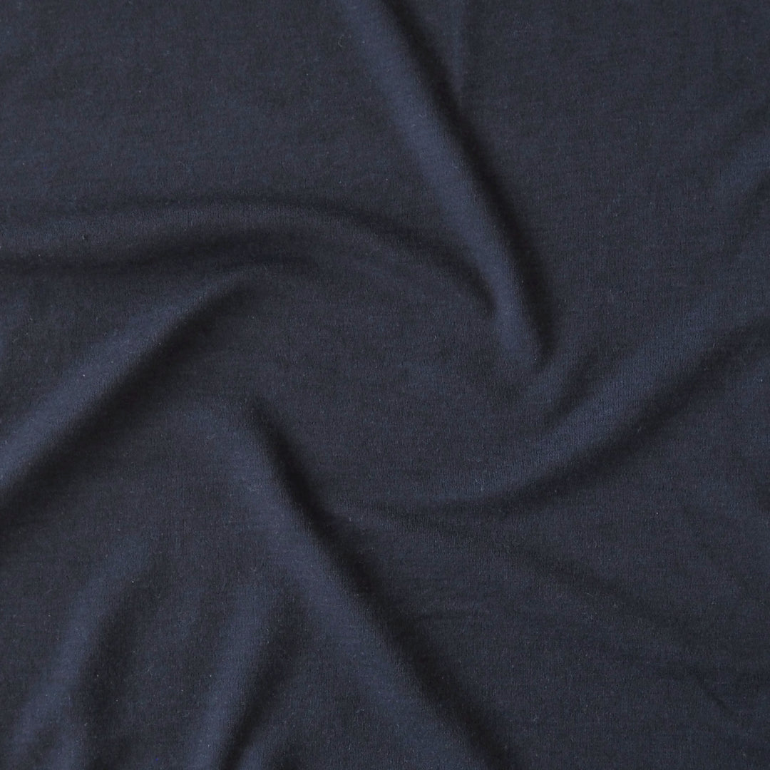 Close-up of navy blue merino wool jersey fabric with visible texture