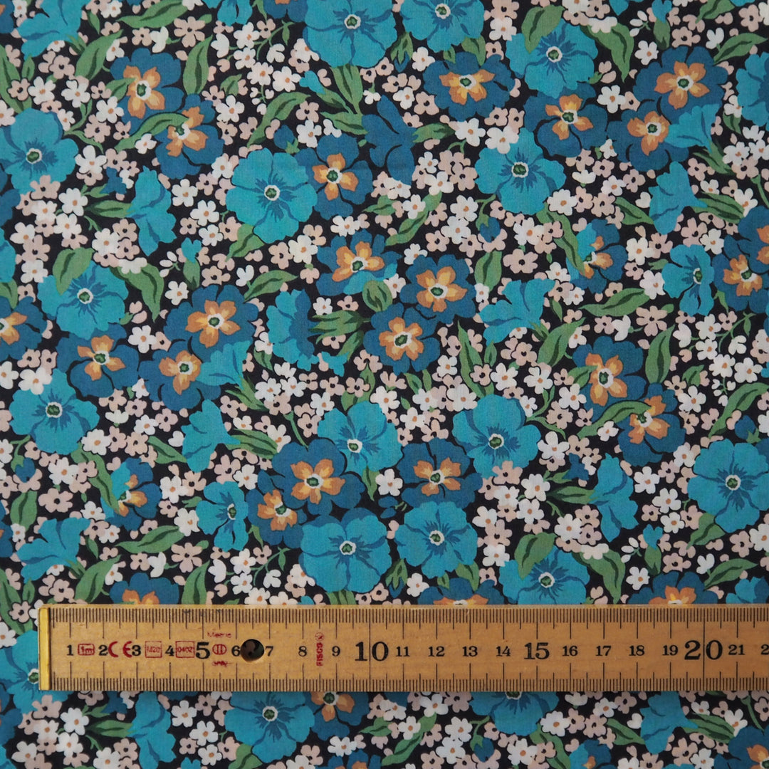 Liberty floral fabric pattern with blue, orange, and white flowers on a black background