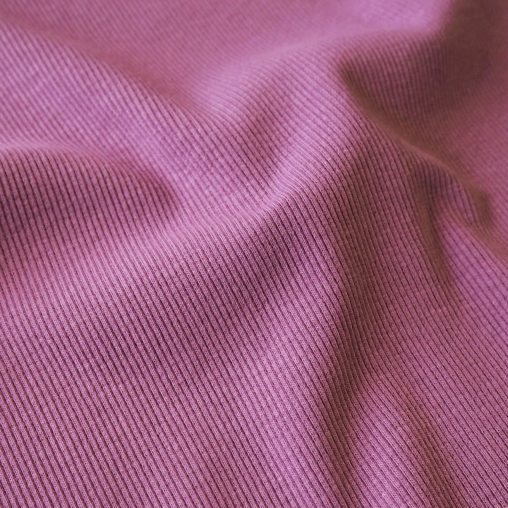 Close-up of orchid pink ribbing fabric with a ribbed texture