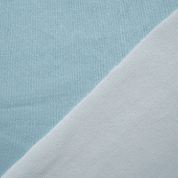 Close-up of light blue fabric with a subtle texture on a matching background