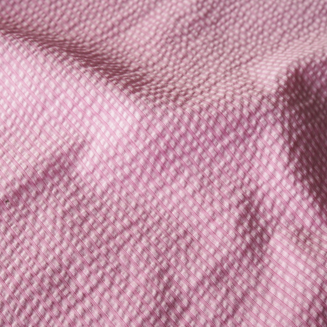 Pink striped cotton seersucker fabric with visible texture and subtle stripe pattern