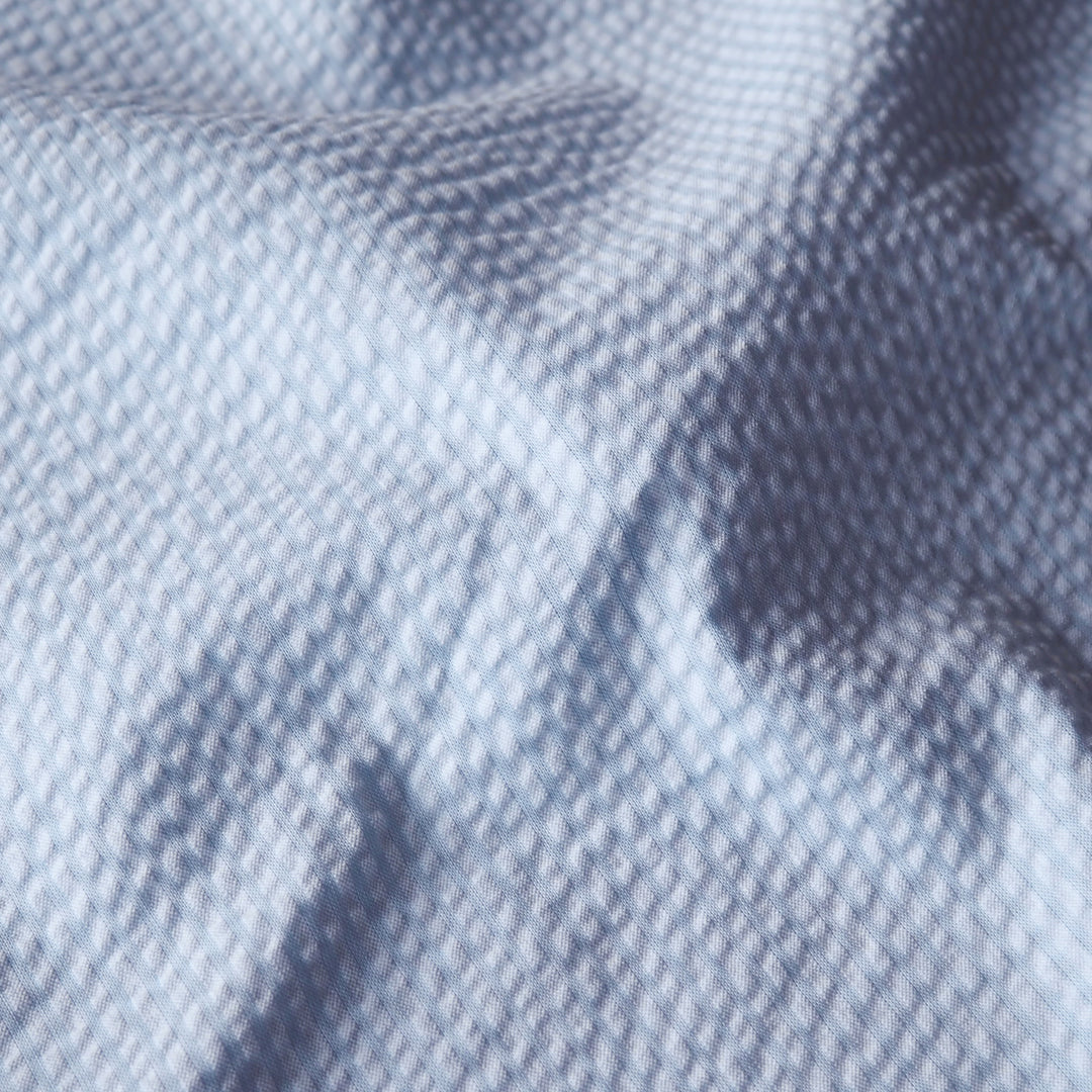 Light blue textured cotton seersucker dressmaking fabric with subtle stripes
