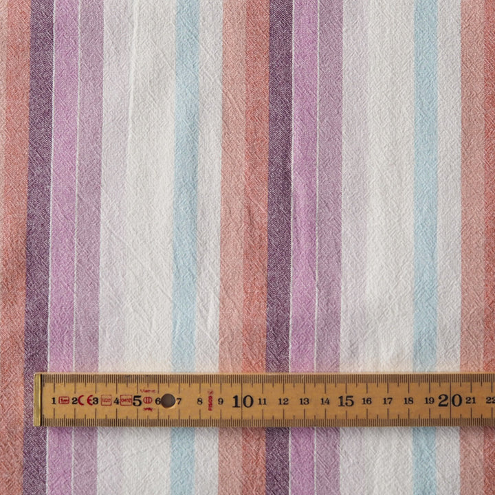 Striped yarn dyed cotton dressmaking fabric in pastel sunset colours