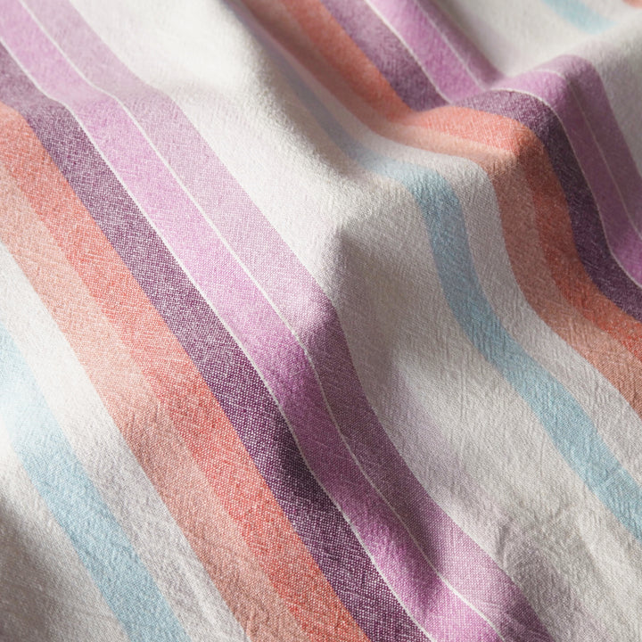 Striped yarn dyed cotton dressmaking fabric in pastel sunset colours