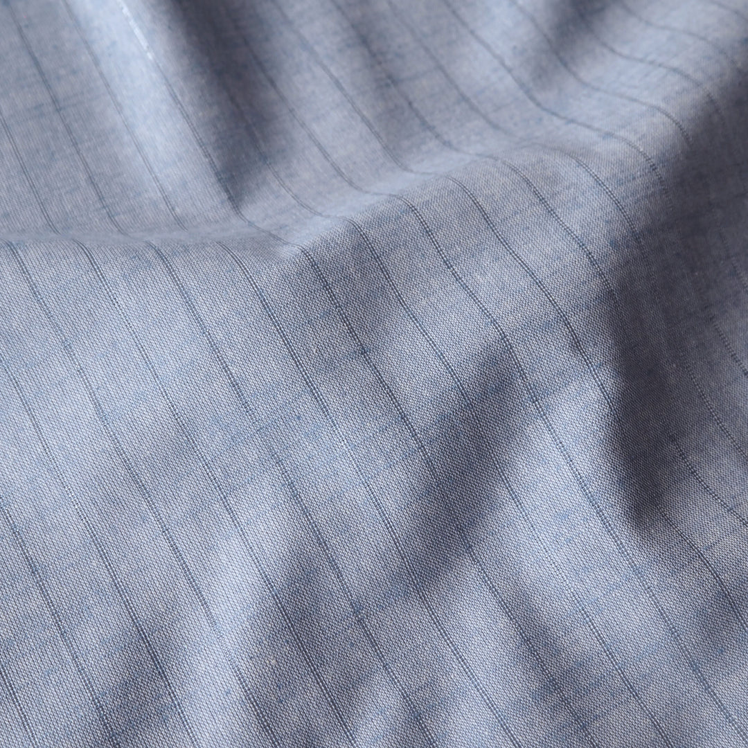 Pale blue chambray cotton dressmaking fabric with subtle silver lurex vertical stripe