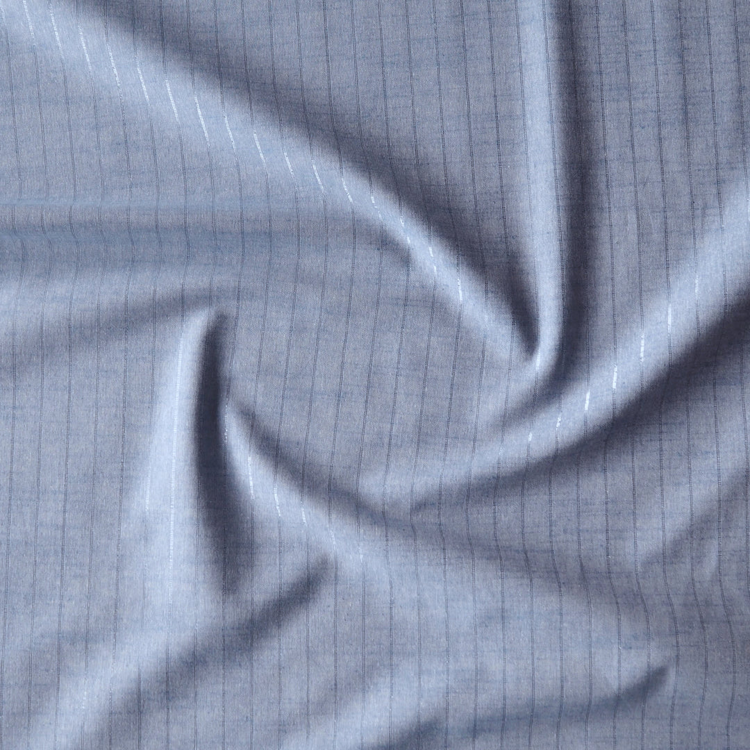 Pale blue chambray cotton dressmaking fabric with subtle silver lurex vertical stripe
