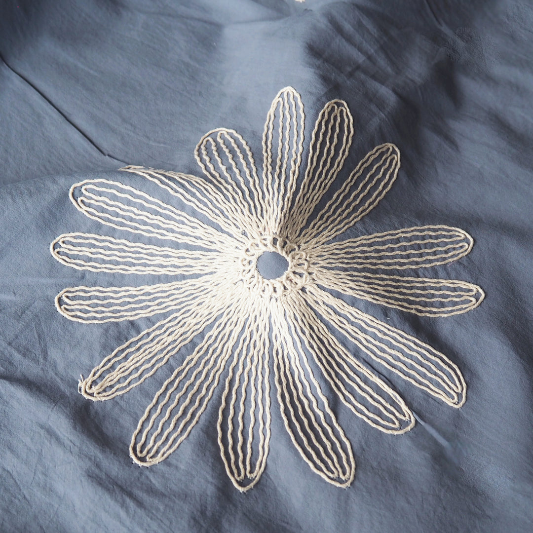 Chalky blue large scale embroidered daisy cotton dressmaking fabric