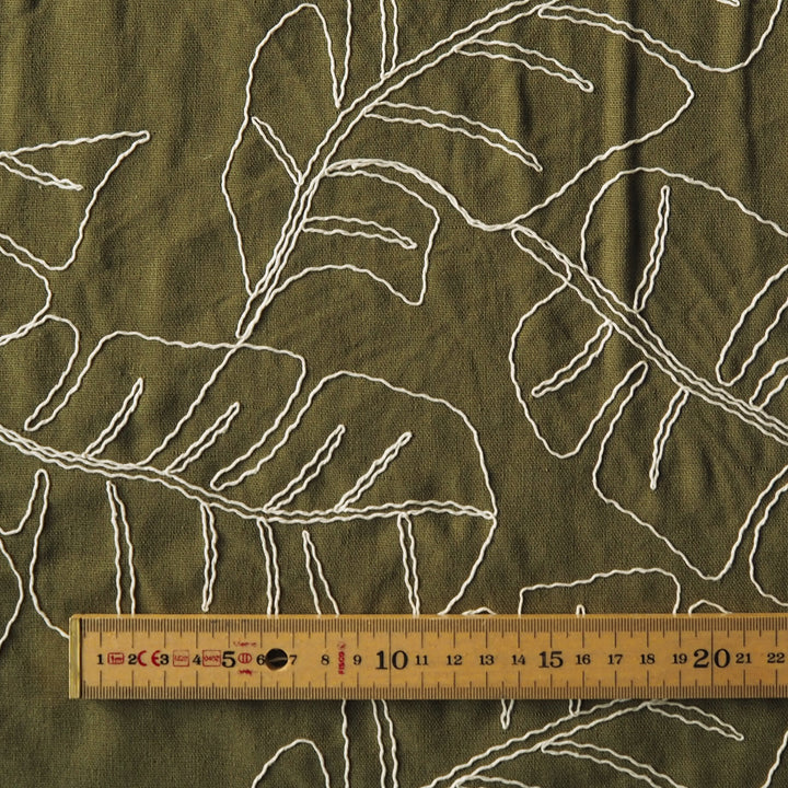 Olive green viscose linen dressmaking fabric with embroidered banana leaf pattern