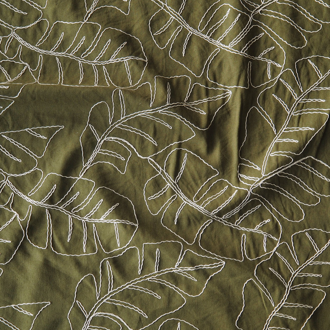 Olive green viscose linen dressmaking fabric with embroidered banana leaf pattern