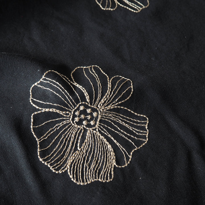 Black viscose linen dressmaking fabric with white floral embroidery pattern