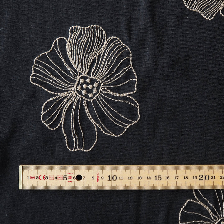 Black viscose linen dressmaking fabric with white floral embroidery pattern