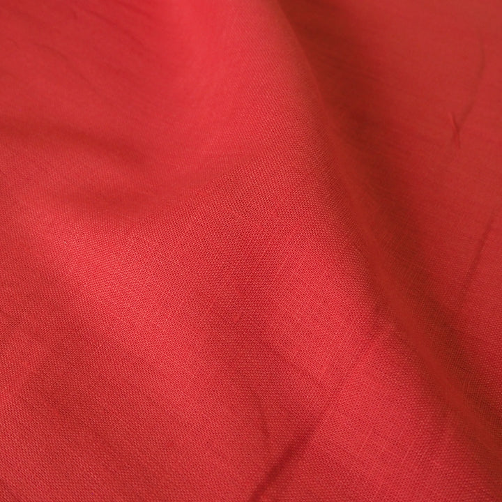 Linen dressmaking fabric in a bright coral orange-pink colour