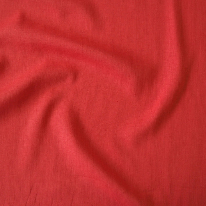 Linen dressmaking fabric in a bright coral orange-pink colour