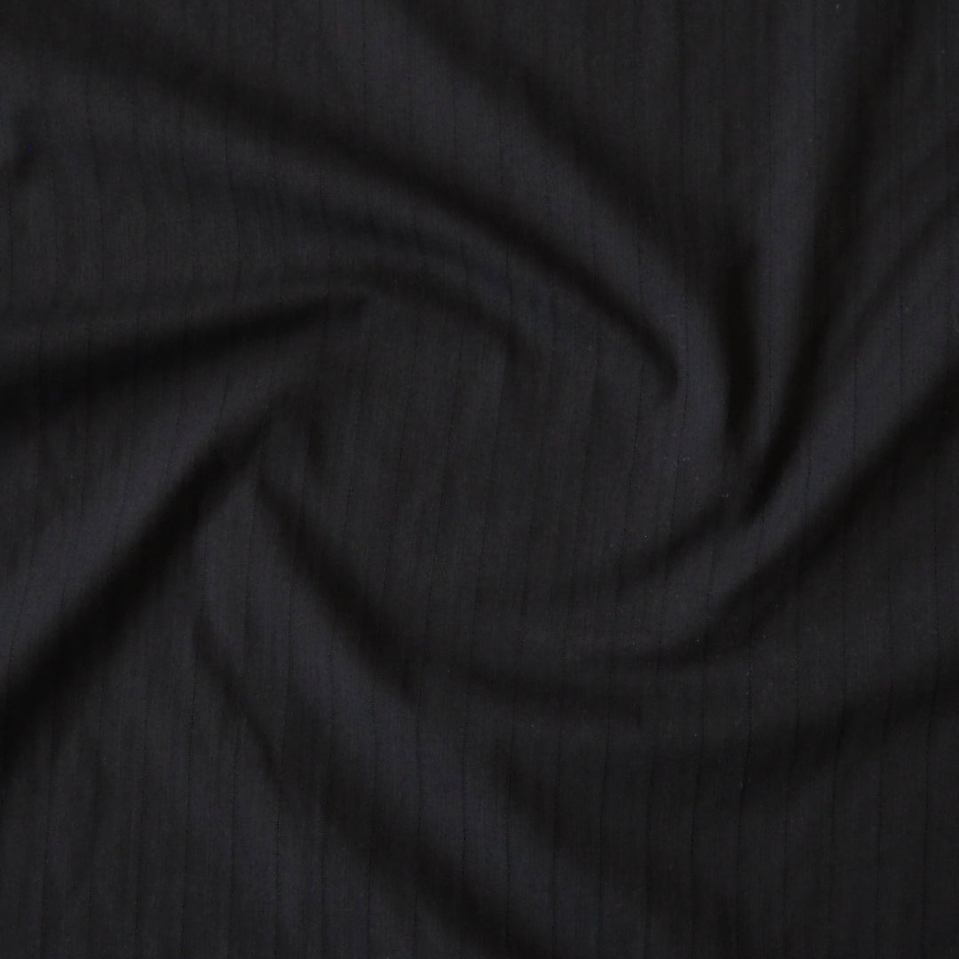 Black cotton dressmaking fabric with subtle stripe woven pattern