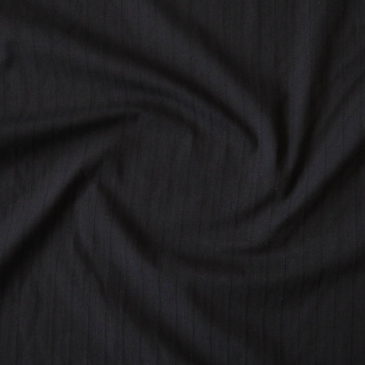 Black cotton dressmaking fabric with subtle stripe woven pattern