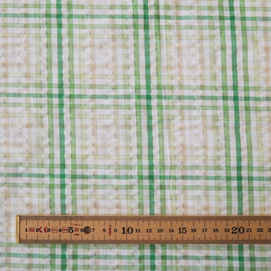 Cotton dressmaking fabric with green check on a white background