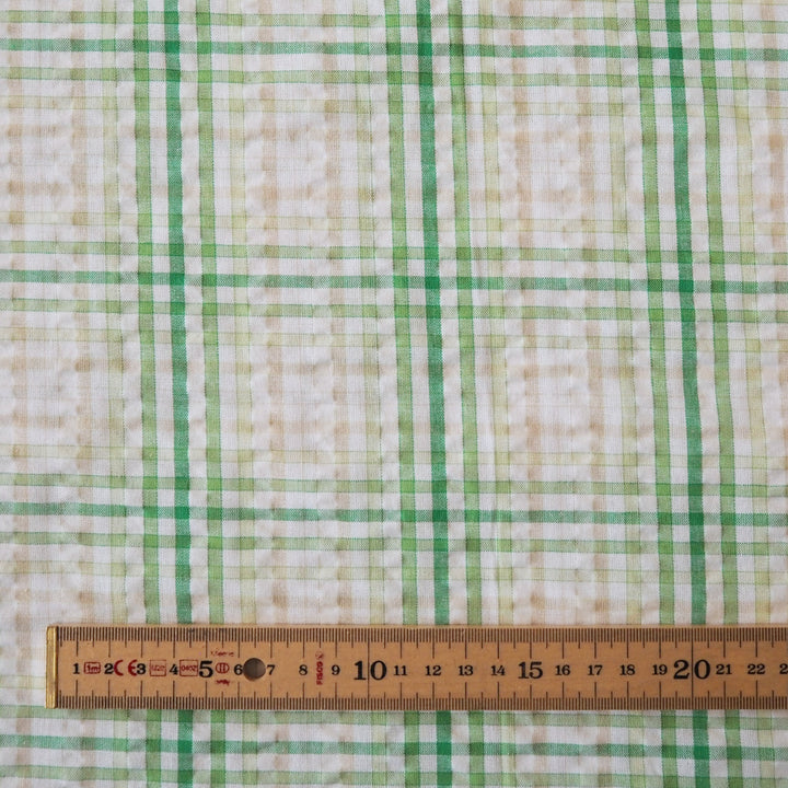 Cotton dressmaking fabric with green check on a white background