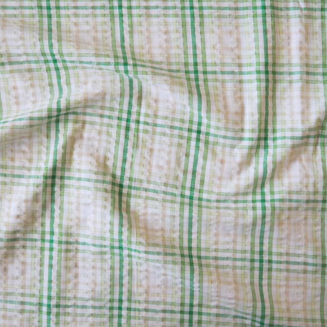Cotton dressmaking fabric with green check on a white background