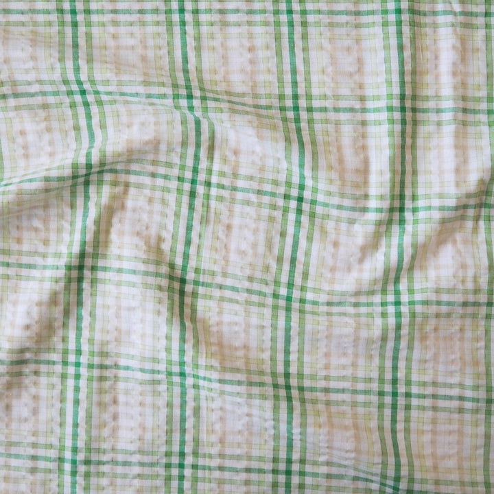 Cotton dressmaking fabric with green check on a white background