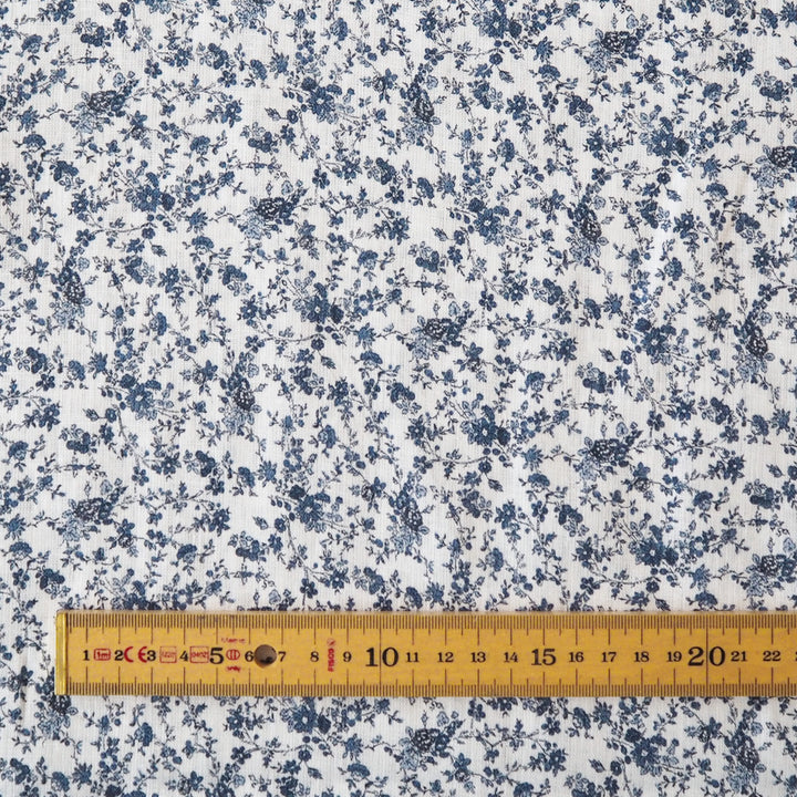 White linen dressmaking fabric with blue floral pattern