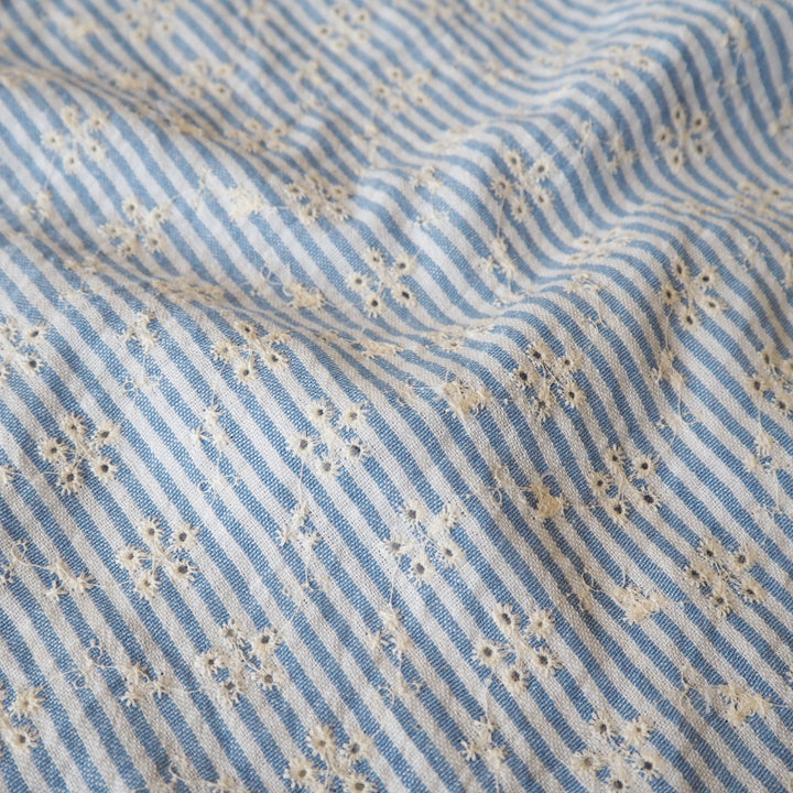 Cotton dressmaking fabric with blue and white design and floral embroidery