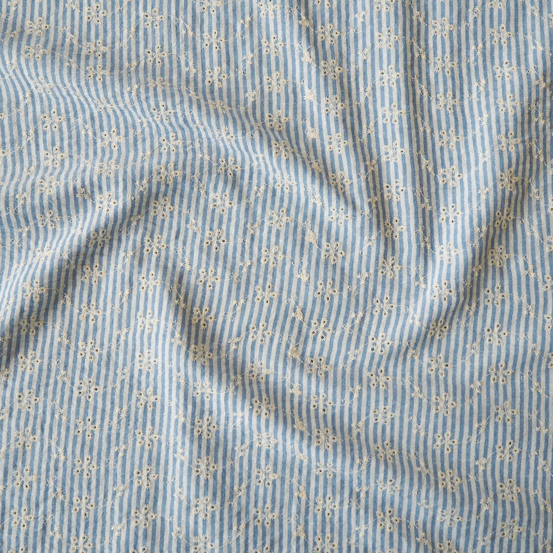 Cotton dressmaking fabric with blue and white design and floral embroidery