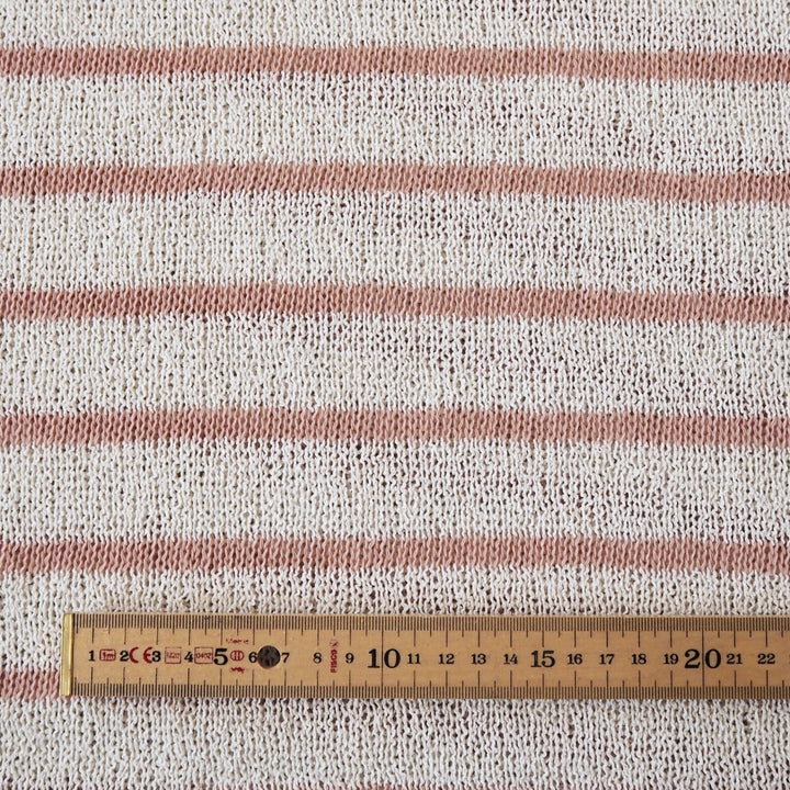 Loose knitted dressmaking fabric with rose pink and ecru stripes