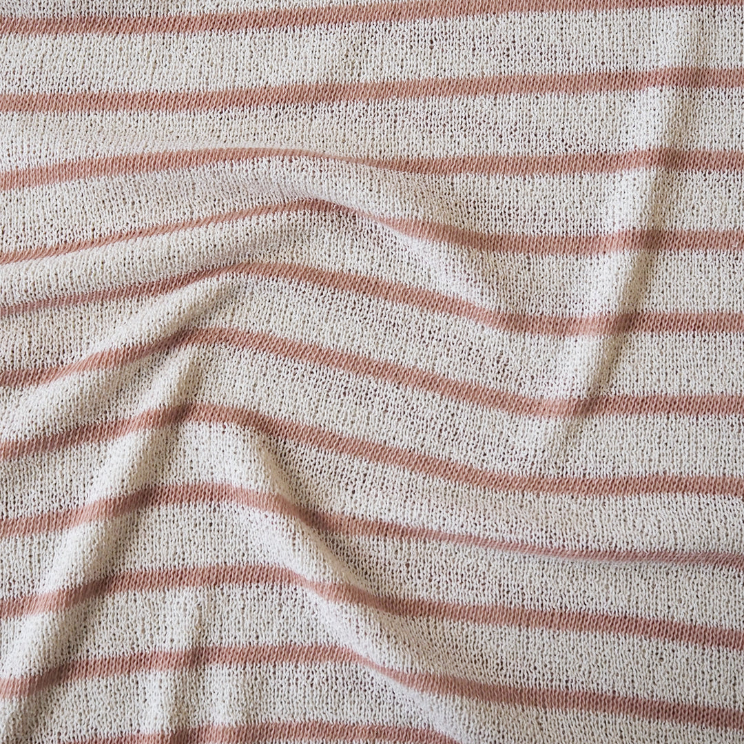 Loose knitted dressmaking fabric with rose pink and ecru stripes