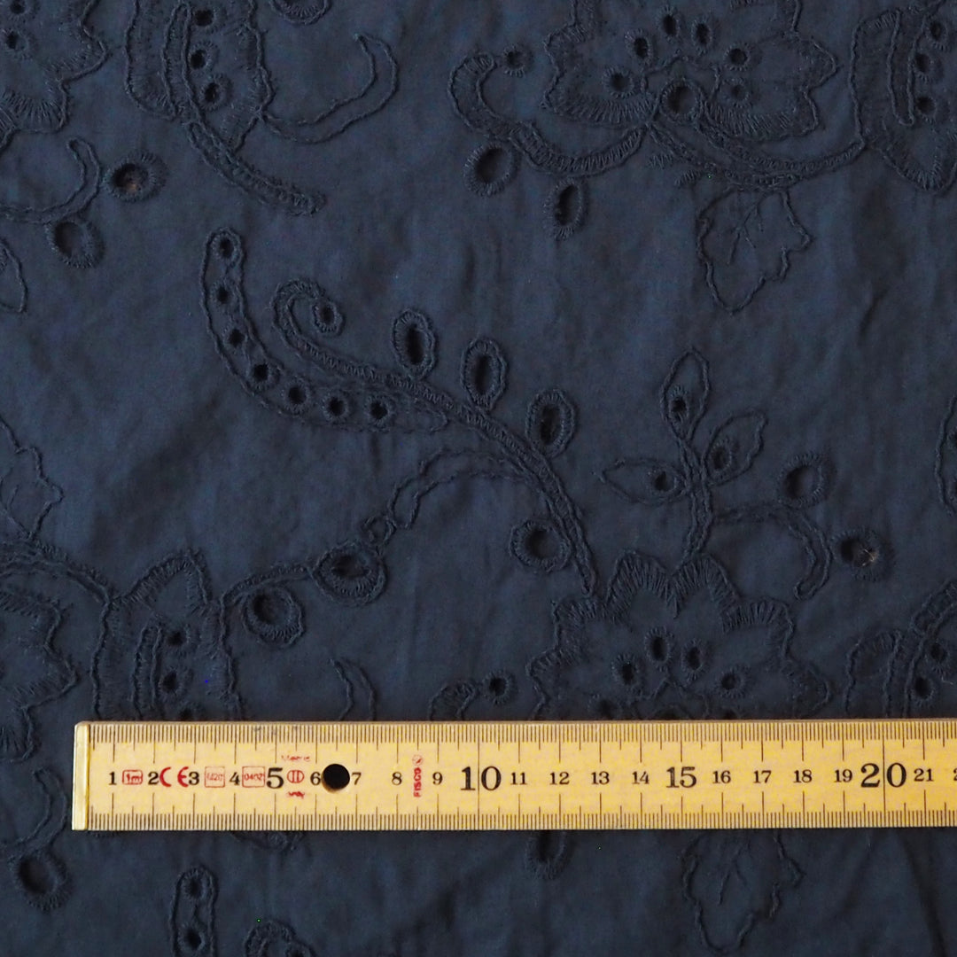 Navy blue embroidered cotton dressmaking fabric with floral pattern