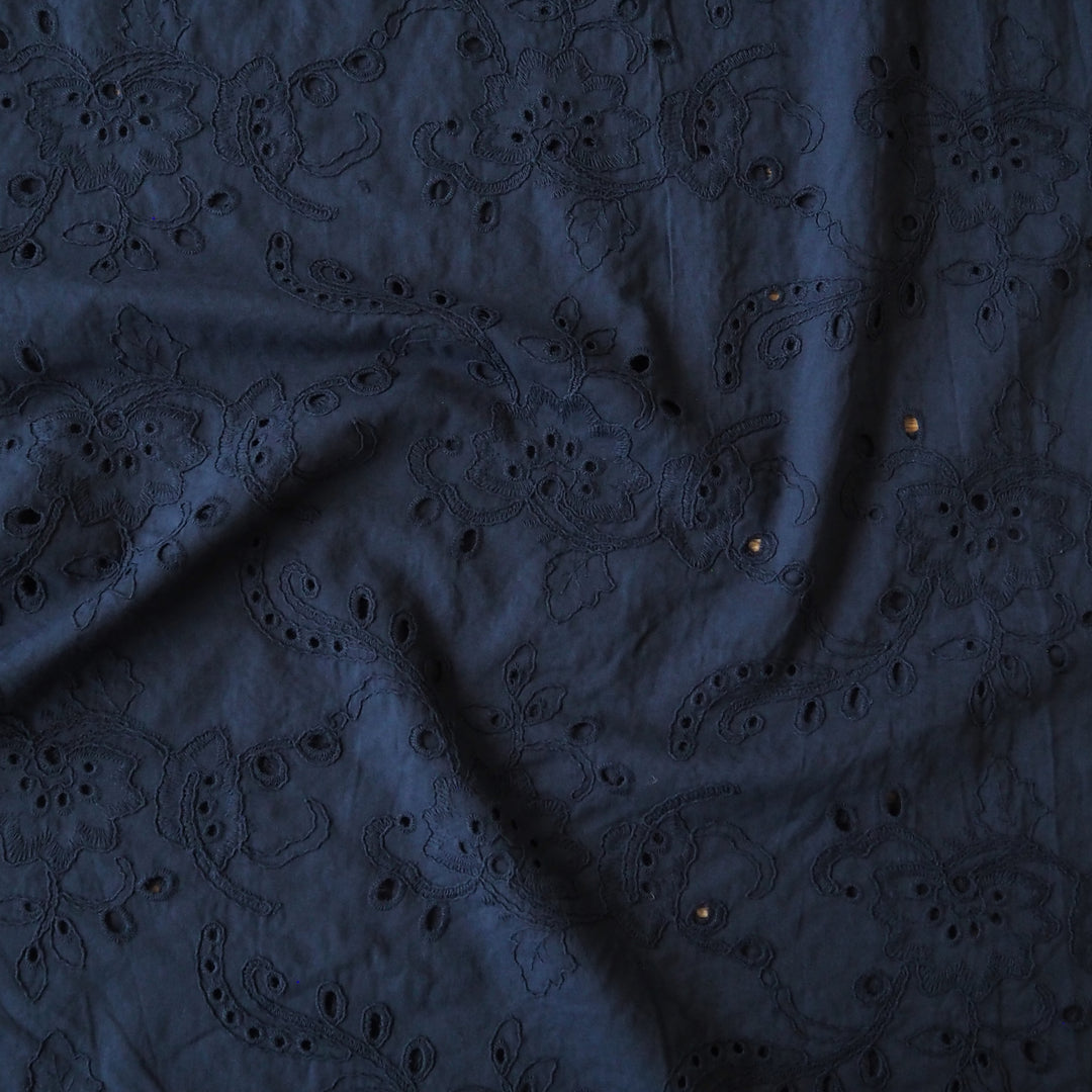 Navy blue embroidered cotton dressmaking fabric with floral pattern