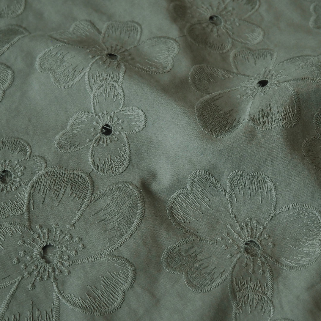 Sage green embroidered cotton dressmaking fabric with floral pattern