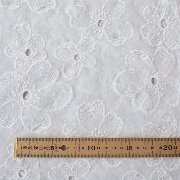 White embroidered cotton dressmaking fabric with floral pattern