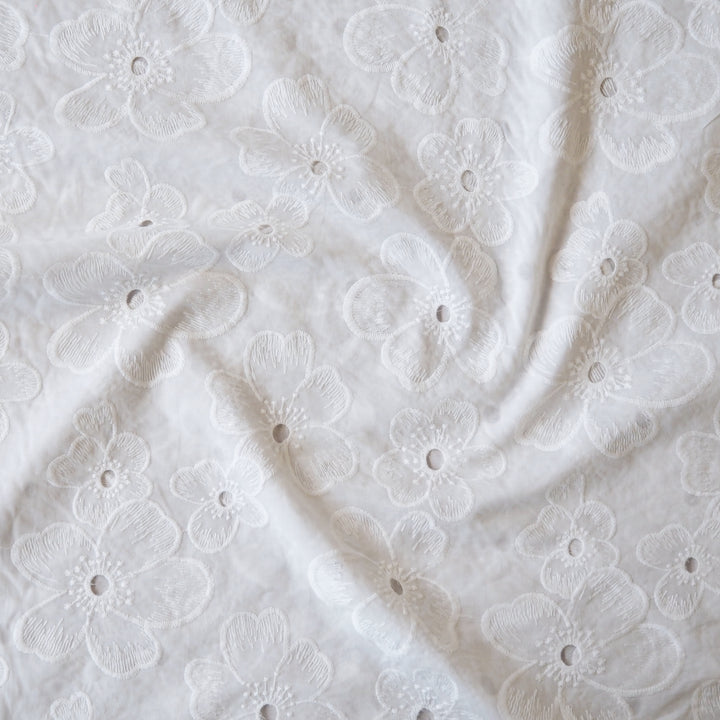 White embroidered cotton dressmaking fabric with floral pattern