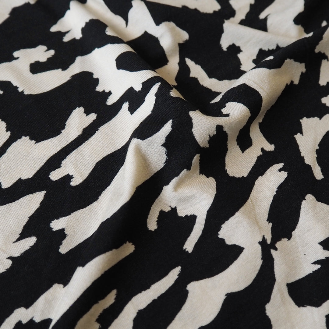 Black and cream stretchy viscose jersey dressmaking fabric with abstract pattern