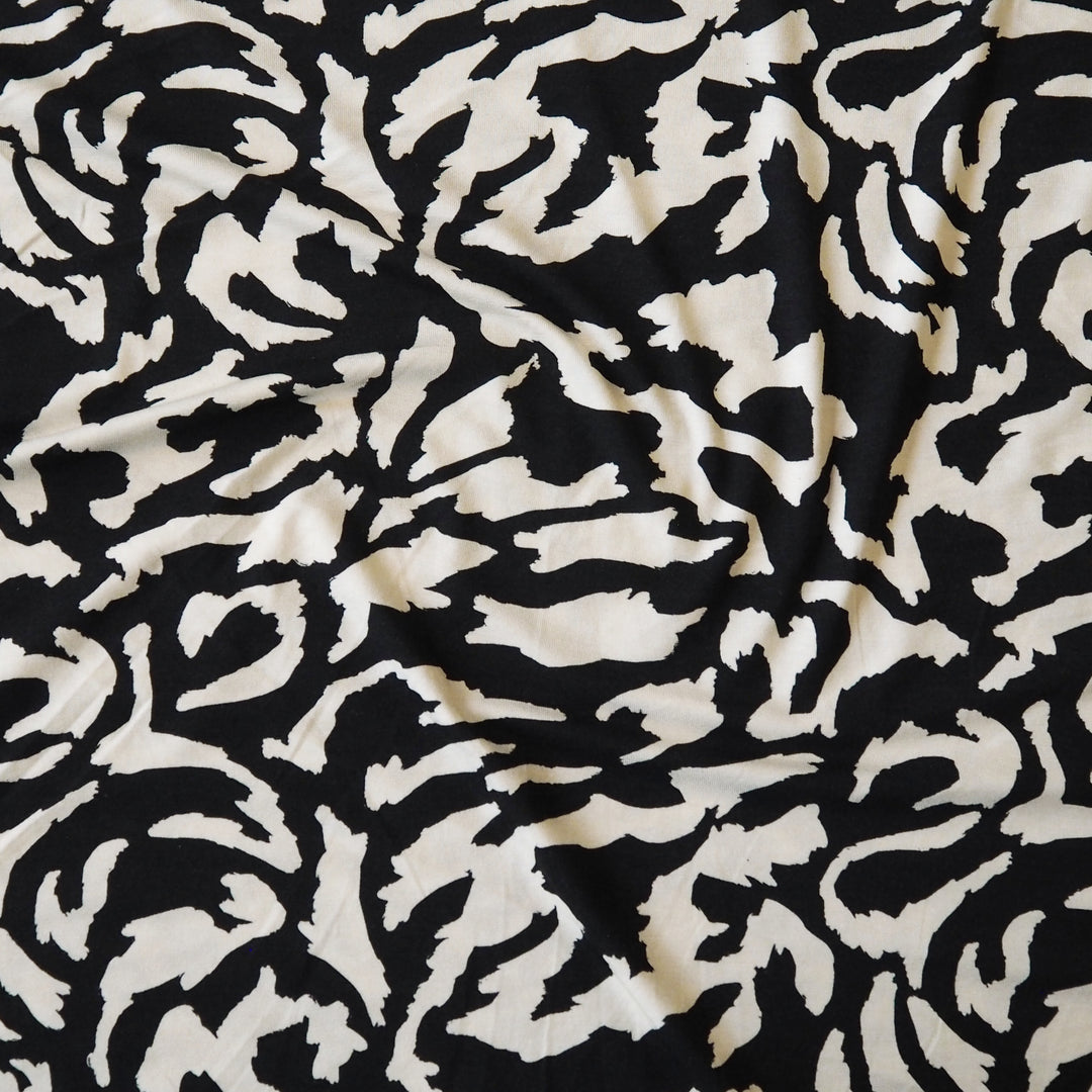 Black and cream stretchy viscose jersey dressmaking fabric with abstract pattern