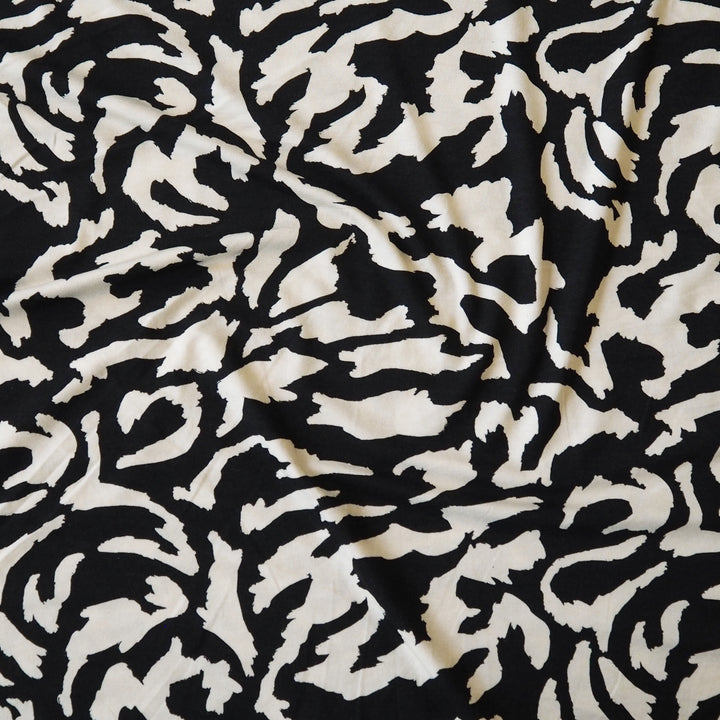 Black and cream stretchy viscose jersey dressmaking fabric with abstract pattern