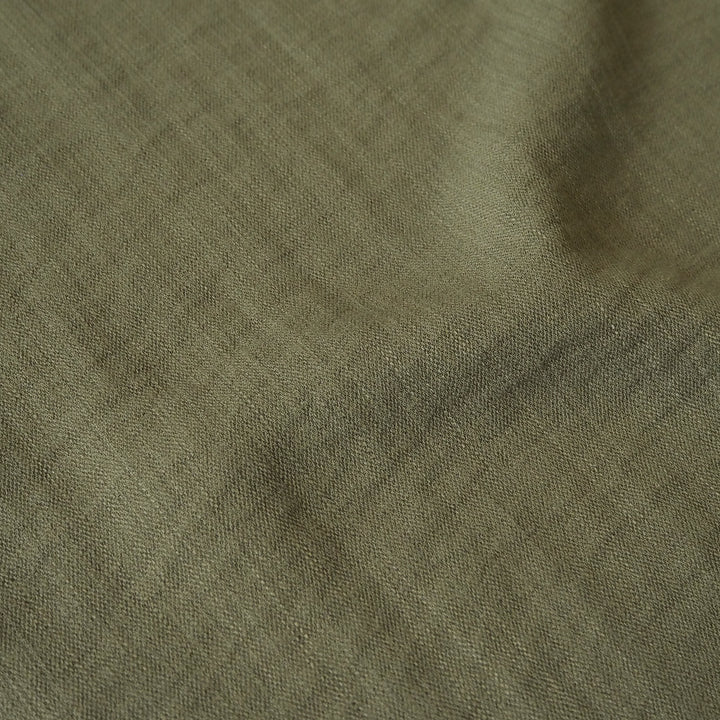 Close-up of olive green viscose blend dressmaking fabric with visible texture