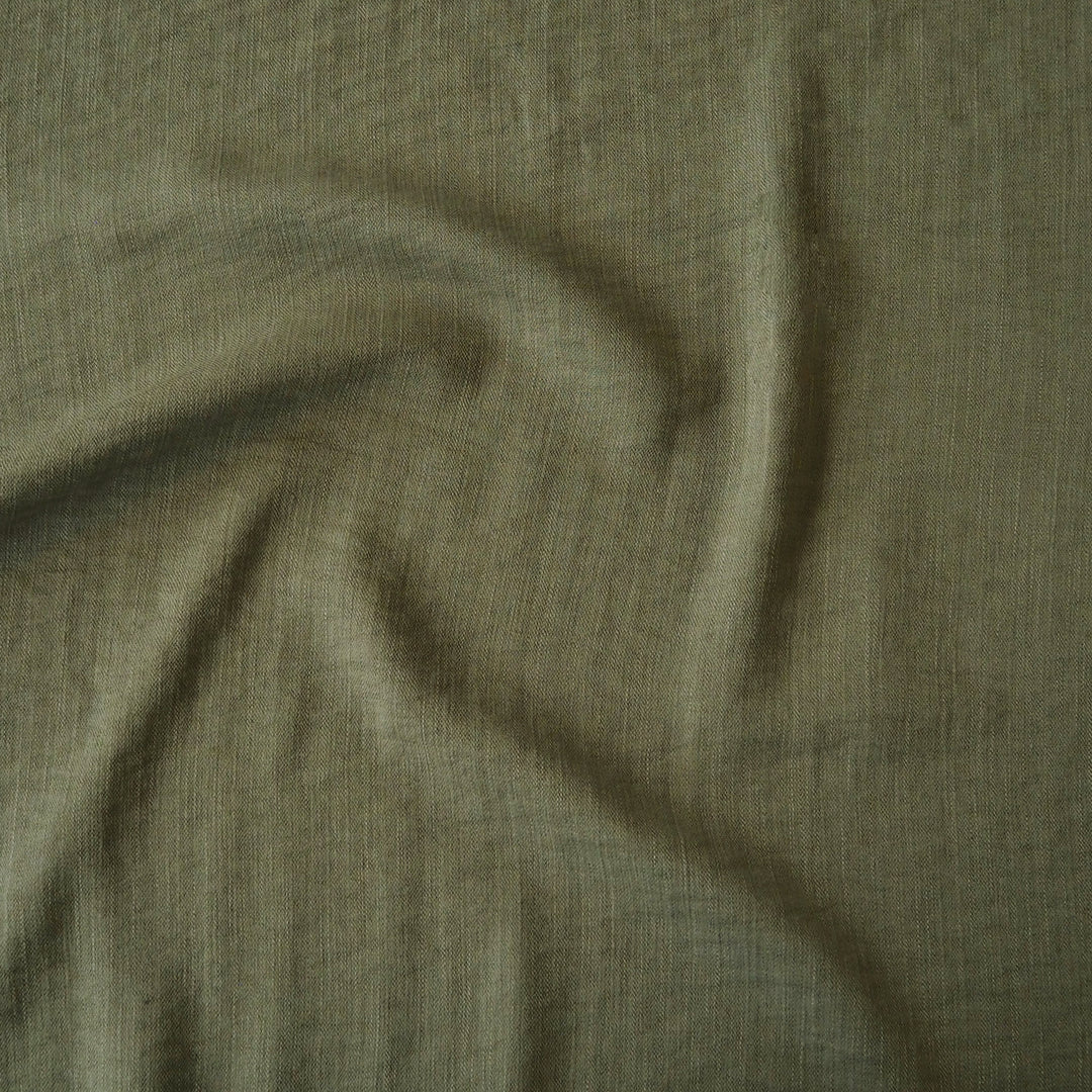 Close-up of olive green viscose blend dressmaking fabric with visible texture