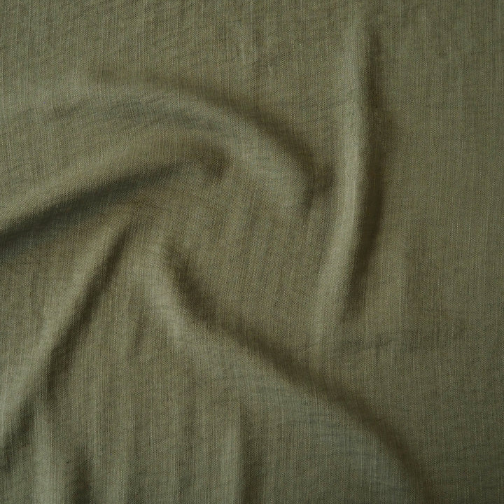 Close-up of olive green viscose blend dressmaking fabric with visible texture