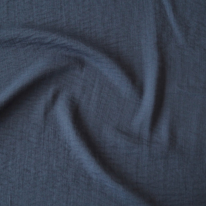 Close-up of navy viscose blend dressmaking fabric with visible texture