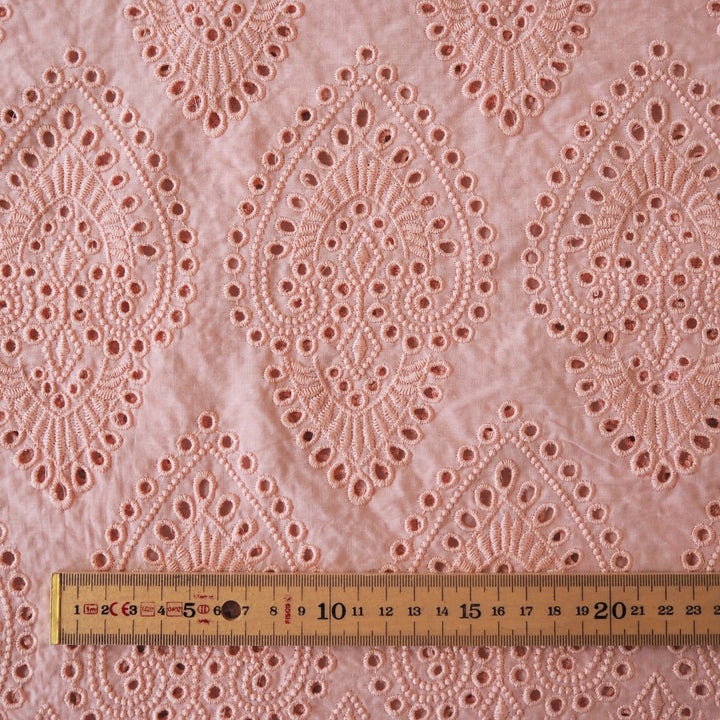 Peachy pink embroidered cupro dressmaking fabric with geometric eyelet pattern