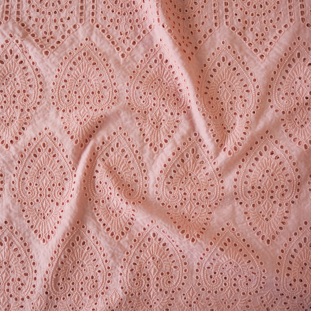 Peachy pink embroidered cupro dressmaking fabric with geometric eyelet pattern