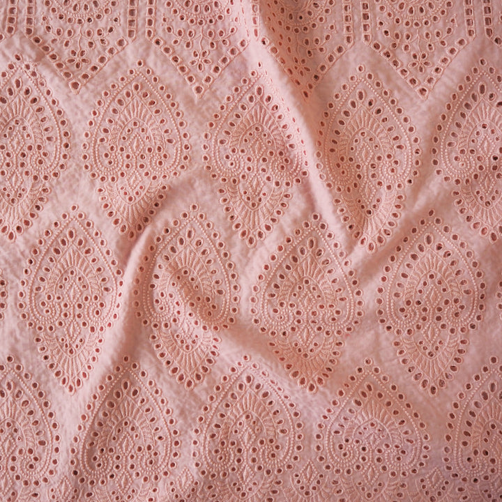 Peachy pink embroidered cupro dressmaking fabric with geometric eyelet pattern