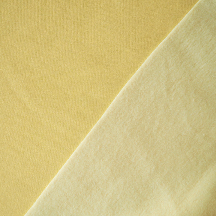 Buttercream yellow fleeceback organic cotton sweatshirting fabric, cosy and stretchy for sweatshirts and joggers.