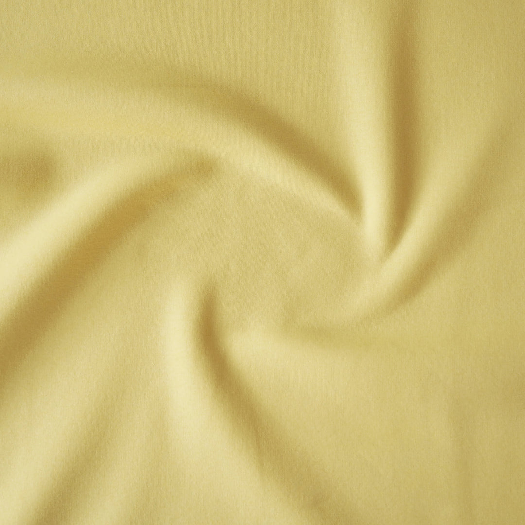 Buttercream yellow fleeceback organic cotton sweatshirting fabric, cosy and stretchy for sweatshirts and joggers.