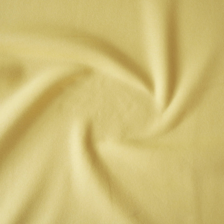 Buttercream yellow fleeceback organic cotton sweatshirting fabric, cosy and stretchy for sweatshirts and joggers.