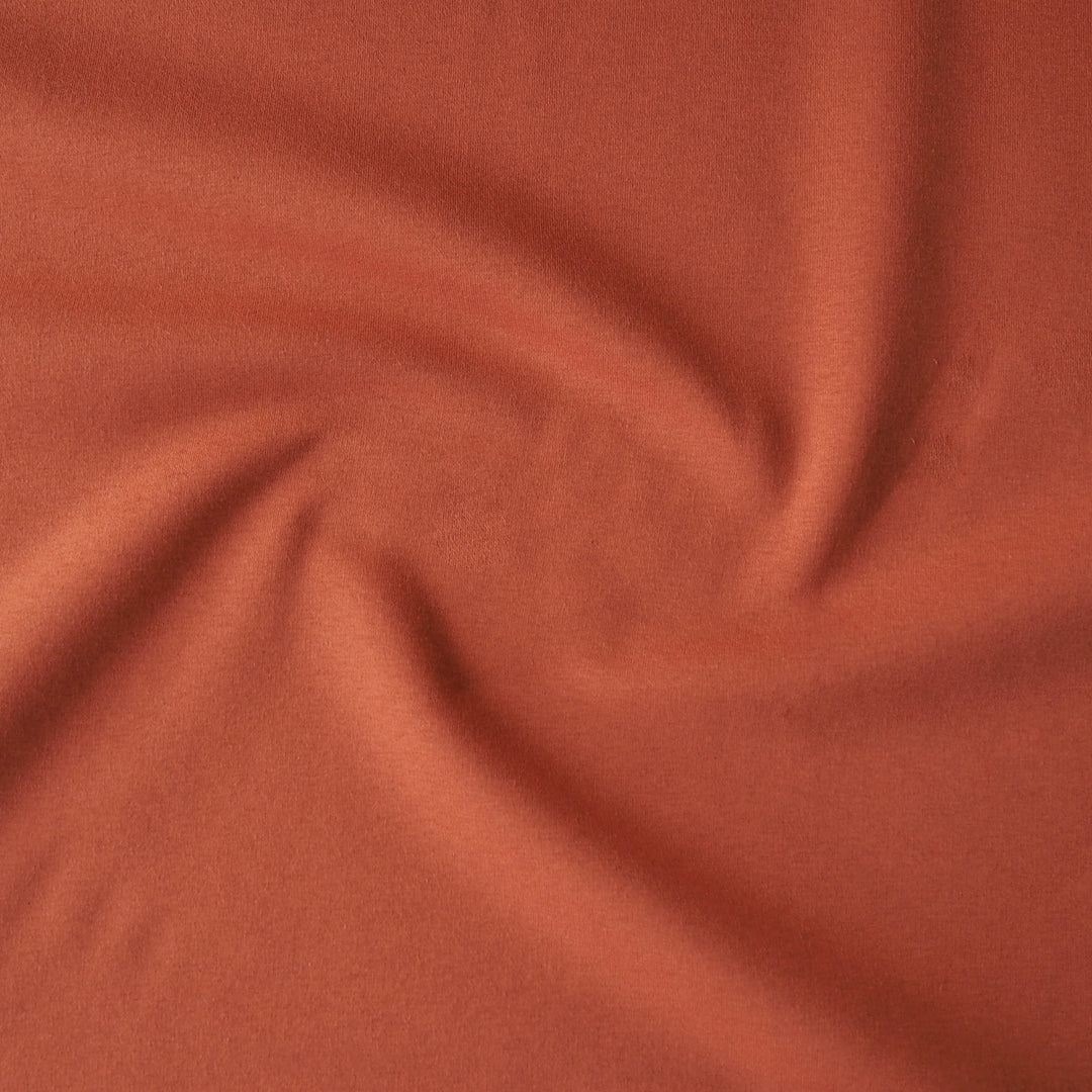 Terracotta fleeceback organic cotton sweatshirting fabric, cosy and stretchy for sweatshirts and joggers.